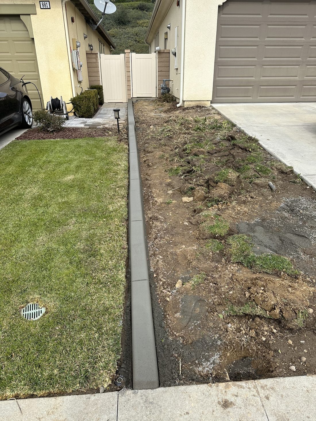 Clean concrete curbing bordering a new lawn and driveway