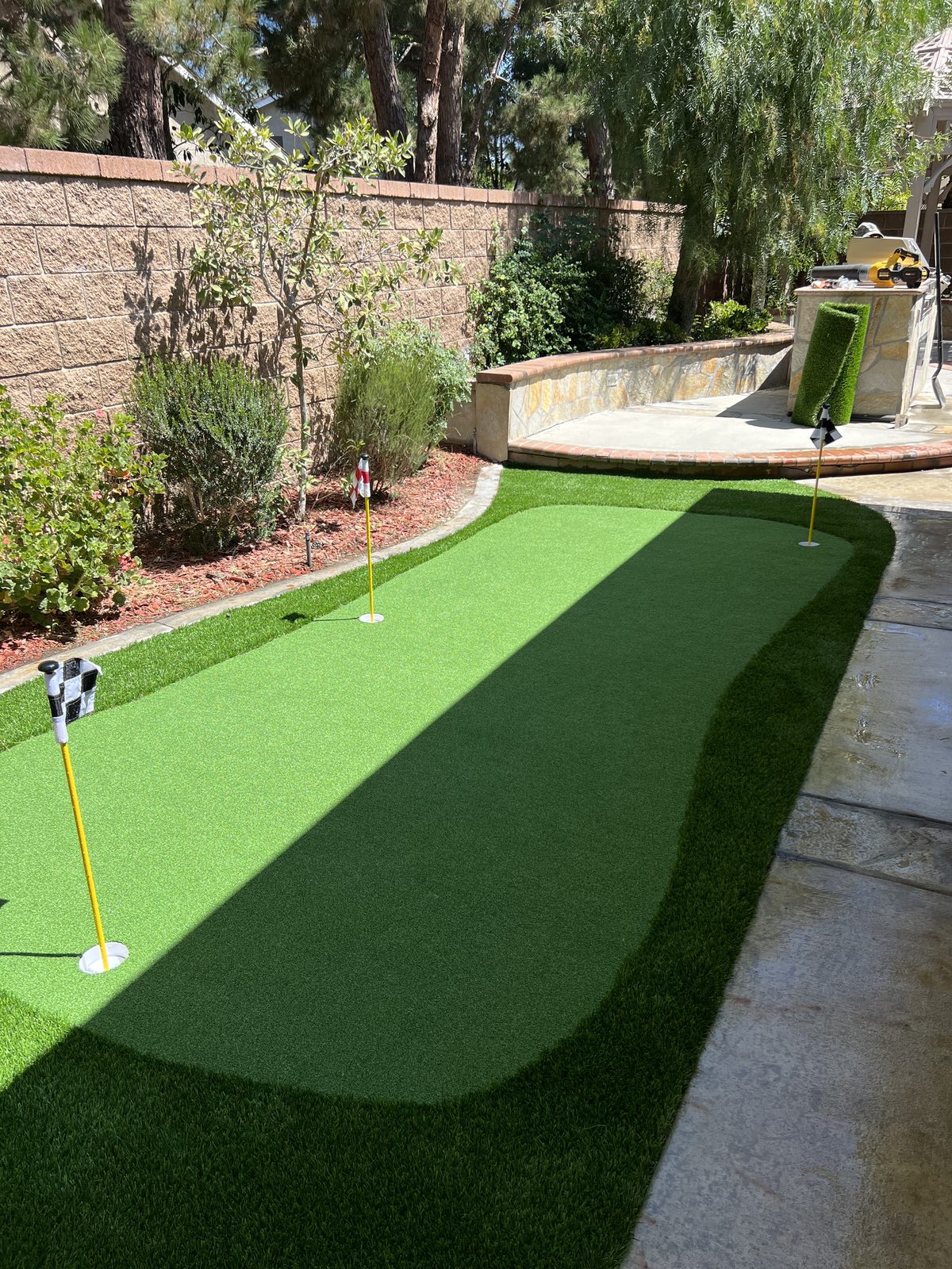 Backyard artificial turf putting green with flag
