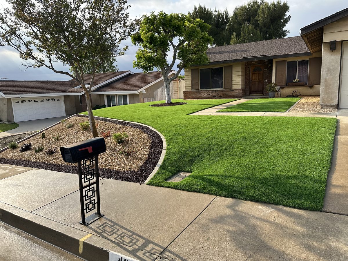 Curved artificial turf lawn and clean concrete on a ranch-style home